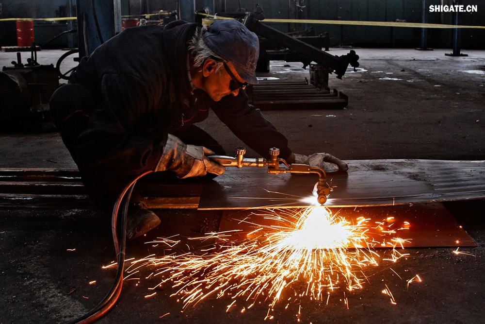 在工業(yè)生產(chǎn)中，鋼板切割是一項至關(guān)重要的工藝，廣泛應(yīng)用于機械制造、建筑、橋梁建設(shè)等多個領(lǐng)域。為了滿足不同項目的需求，鋼板切割采用了多種加工方式。本文將詳細介紹鋼板切割中常見的幾種加工方式，包括火焰切割、激光切割、等離子切割、水刀切割以及機械切割等。    一、火焰切割    火焰切割是利用氧氣和乙炔的燃燒產(chǎn)生的高溫火焰來切割鋼板的一種加工方式。在切割過程中，火焰將鋼板局部加熱至熔化狀態(tài)，同時氧氣流將熔化的金屬吹走，形成切口。火焰切割設(shè)備相對簡單，成本低廉，適用于切割厚度較大的鋼板。然而，由于切割過程中產(chǎn)生的熱影響區(qū)較大，易導(dǎo)致鋼板變形和材質(zhì)變化，因此精度和表面質(zhì)量相對較低。          二、激光切割    激光切割是利用高功率密度的激光束照射鋼板表面，使鋼板迅速熔化、汽化或達到點燃點，同時以高速氣流將熔化或燃燒的金屬吹走，形成切口。激光切割具有切割速度快、精度高、熱影響區(qū)小等優(yōu)點，特別適用于切割薄板和中厚板。此外，激光切割還能實現(xiàn)自動化和智能化生產(chǎn)，提高生產(chǎn)效率。            三、等離子切割    等離子切割是利用高溫、高速度的等離子氣體流對鋼板進行切割的一種加工方式。在切割過程中，等離子氣體流將鋼板局部熔化，并通過氣流將熔化的金屬吹走。等離子切割適用于切割中厚板和厚板，具有切割速度快、熱影響區(qū)小、切口平整等優(yōu)點。然而，等離子切割設(shè)備的成本較高，維護也相對復(fù)雜。    四、水刀切割    水刀切割是利用高壓水流對鋼板進行切割的一種加工方式。在切割過程中，高壓水流將鋼板局部沖蝕，形成切口。水刀切割具有切割精度高、表面質(zhì)量好、無熱影響區(qū)等優(yōu)點，特別適用于切割薄板和對表面質(zhì)量要求較高的項目。此外，水刀切割還能實現(xiàn)綠色生產(chǎn)，減少環(huán)境污染。    五、機械切割    機械切割是利用切割機械對鋼板進行切割的一種加工方式，如鋸床切割、銑床切割等。機械切割適用于切割各種厚度和材質(zhì)的鋼板，具有切割精度高、切口平整、適應(yīng)性強等優(yōu)點。然而，機械切割的速度相對較慢，生產(chǎn)效率較低，且對于較厚的鋼板，切割難度較大。            在選擇鋼板切割加工方式時，需要根據(jù)項目的具體需求、鋼板的厚度和材質(zhì)、生產(chǎn)效率和成本等因素進行綜合考慮。對于要求高精度、高表面質(zhì)量的切割項目，激光切割和水刀切割是較為理想的選擇；對于切割厚度較大、對表面質(zhì)量要求不高的項目，火焰切割和等離子切割則更具優(yōu)勢；而對于需要靈活應(yīng)對各種切割需求的場景，機械切割則是一種可靠的選擇。    總之，隨著科技的不斷進步和工業(yè)生產(chǎn)的不斷發(fā)展，鋼板切割加工方式也在不斷創(chuàng)新和完善。了解各種加工方式的優(yōu)缺點，并根據(jù)實際需求選擇合適的加工方式，對于提高鋼板切割的質(zhì)量和效率具有重要意義。